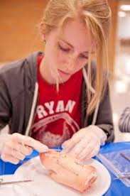 Students practice stitching pigs' feet