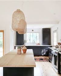 Black Kitchen Cabinets With Light Wood Countertops And Rattan Pendant Lights Kitchen Interiordesign Stylish Kitchen Design Bohemian Kitchen Stylish Kitchen