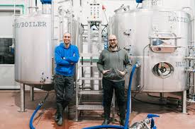 Restaurants in der nähe von boiler brewing company auf tripadvisor: Content Male Coworkers Looking At Camera While Sitting On Stairs Between Metal Tanks In Brewing Company Stockphoto