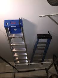Easy Ladder Storage Above The Garage Door Using A Clothes Closet Rod And Ladder Hook Ladder Storage Diy Garage Storage Garage Organization