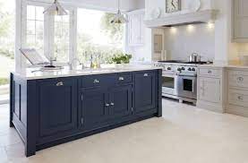 Exactly the color of faded denim, these cabinets, with a mix of solid and glass fronts, create a perfectly serene vibe in the spacious kitchen. Blue Kitchen Island With Butcher Block Cream Wall Painting White And Black Tile Backsplash Exposed Gre Blue Kitchen Island Blue Kitchens Black Kitchen Cabinets