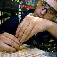 Machinery Repairman 2nd Class 2nd Class Brian Bennett makes a fitting for  welding qualifications using a CNC lathe in the machine shop of the  aircraft carrier USS George H.W. Bush (CVN 77). -