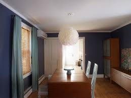 Another wall contains a series of white trimmed mirrors, and the centerpiece of the design is a lovely light fixture hanging above the dining table. A New Dark Dining Room Little Victorian