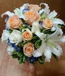 Modish groom putting a golden ring on the bride's finger during the wedding ceremony. Royal Blue Peach And White Bridal Bouquet Hand Tied Bridal Bouquet In Tillamook Or Anderson Florist