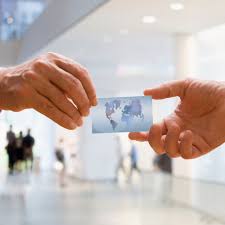 Caucasian middle aged man holding business card toward viewer. A Brief History Of Business Card Use