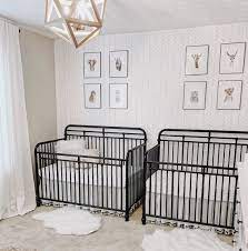 A gender neutral nursery with retro wooden furniture, a navy chair, a boho rug and shelves. Tips And Ideas To Design A Twin Nursery
