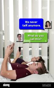 Couple texting in bed Stock Photo - Alamy