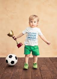 Download Placeit T Shirt Mockup Of A Baby Boy Holding A Soccer Trophy