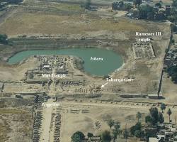 Image of Sacred Lake (Isheru) surrounding the Temple of Mut, with the temple structures reflected in the water.