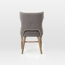 An update to the classic wingback, our dining chair features a rolled border along the sides and back, diamond tufting and nailhead trim along the seat rim. Nailhead Upholstered Dining Chair
