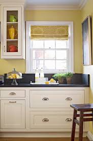 The kitchen offers a rough wood counter surrounding a double basin farmhouse sink with painted white cabinetry. 19 Popular Kitchen Cabinet Colors With Long Lasting Appeal In 2021 Yellow Kitchen Walls Kitchen Wall Colors Grey Kitchen Furniture