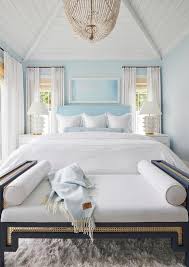 A White Beaded Chandelier Hangs From A White Plank Vaulted Bedroom Ceiling Over A Navy Blue Cane Bench Pl Beach House Bedroom White Beach Houses House Interior