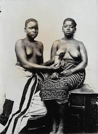 Two women from Zanzibar, one milking the other's right breast into a cup. |  Wellcome Collection