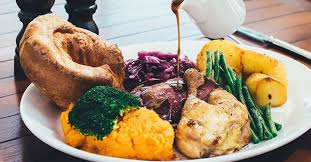 Roasted turkey garnished with cranberries on a rustic style table decoraded with pumpkins, vegetables, pie, flowers. 6 Of Your Favourite Dubai Roast Dinners Delivered To Your Door