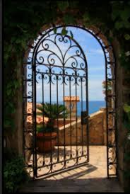 Entry of gray stucco, beautifully filigreed iron gate, and white climbers growing out of box border. 5 Stunning Examples Of Wrought Iron Gate Designs Dean Wilson Iron