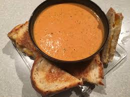 This thick and creamy tomato soup is brought to life with garlic and fresh basil. Homemade Tomato Basil Soup Served With Cheese Sandwiches On Garlic Sourdough Bread Food