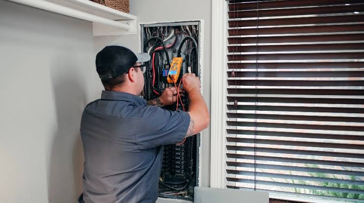 Fitter installing a modern light switch faceplate in Greenwich SE10