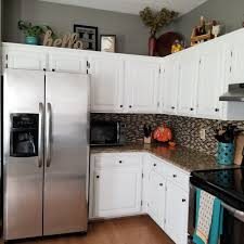 Adding billowy fern leaves, fake flower stems, and crawling ivy are all popular ways to bring the beauty of the outdoors into your kitchen. How To Decorate Above Kitchen Cabinets Decorating Above Kitchen Cabinets Above Kitchen Cabinets How To Decorate Above Kitchen Cabinets