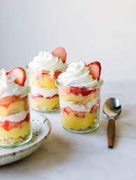 Cup of cappuccino and cup of coffee with two glass cups of layered fruit and custard served outdoors. Trifle Glass Desserts Archives Pretty Simple Sweet