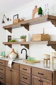 This wall decor showcases rustic floral pattern vine carvings, a central floral pendant, and other small scrolled iron accents in rubbed bronze finish. White Kitchen With Bronze Accents Design Ideas