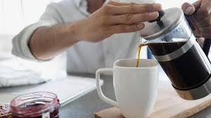 A cup of coffee over spills on a table. Dark Roast Coffee May Reduce Risk Of Alzheimer S Parkinson S Diseases