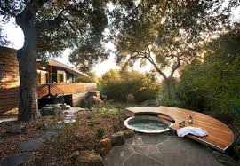 The privacy screens on two sides also work to provide protection from the elements, and you can open up the curtains to create a private space for soaking in the hot tub. 8 Ways To Beautifully Integrate An Outdoor Hot Tub