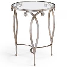 There is a brass colored ornamentation on the corner of each leg. Silver Table Round Glass Top Table In Silverleaf Finish