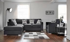Corner of living room with white walls, tiled floor, long gray sofa standing near coffee table and fireplace. Cosy Corner Sofa