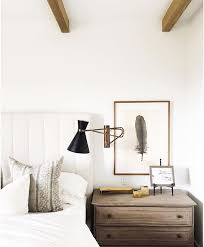 Minimalist Bedroom White Walls White Upholstered Headboard Sconce Side Table And Art Hanging Above It Home Decor Home Decor Bedroom Bedroom Design