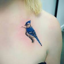 Black Bird With Blue Neck Michigan Blue Jay Tattoo On The Chest Blue Jay Tattoo Black Ink Tattoos Bird Tattoos For Women