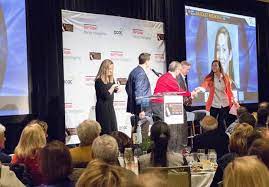 Rachel Ryan And Dave Koehn Introduce Panelist Chelsea Shine Wilson At The Jimmy Miller S Bracket Breakfast For Piedmont Casa On John Grisham Magic Man Emcee