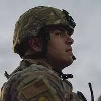 U.S. Army Spc. Daniel Ulsh pulls weeds along a curb