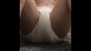 Cute teen boy makes wee wee in his reusable diaper