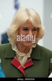 The Queen Consort, Chancellor of the University of Aberdeen, receives a  bouquet of flowers from (left to right) Elspeth Cameron and Rosa Alexander  both aged four from the Rocking Horse Nursey as