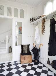Black and white photographs are stacked against a charcoal gray wallpapered wall on either side of a brown wood framed mirror hung above a brown wood buffet cabinet lit with white lamps. 38 Black N White Floor Ideas White Floors Home Interior