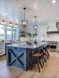Nodding to its homegrown roots, a. Modern Farmhouse Kitchen With Navy Blue Island And Stools Nad Farmhouse Pendant Shiplap C Farmhouse Kitchen Design Home Decor Kitchen Rustic Farmhouse Kitchen