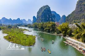 廣西陽朔：乘竹筏賞美景】近日，在廣西桂林陽朔縣，眾多遊客乘坐竹筏遊覽遇龍河，欣賞沿岸的山水風光。