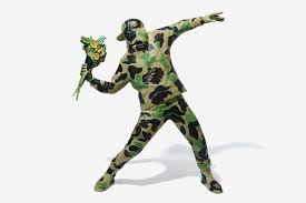 Banksy leads us to believe the subject has armed himself for a riot or a war. Banksy S Iconic Flower Bomber Gets The Bape Treatment
