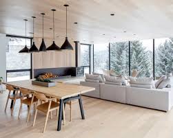 Living room with built in cabinetry, floor to ceiling windows, wool carpet and coffer ceiling detail. Living And Dining Area With Floor To Ceiling Windows Opening Up To View Of The Forest And Mountains Whistler Canada By Evoke International Design Photo Janis Nicolay 2436x1949 Roomporn