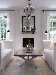 The gray sofas are dressed with white pillows, gray trellis pillows and a fringed gray throw. Why You Should Arrange Two Identical Sofas Opposite Of Each Other Designed