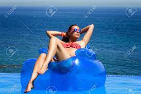 Maybe you would like to learn more about one of these? Beautiful Young Woman Sitting On Inflatable Chair Sunbathing Relax In Swimming Pool With Wonderful Sea Views Stock Photo Picture And Royalty Free Image Image 22737051