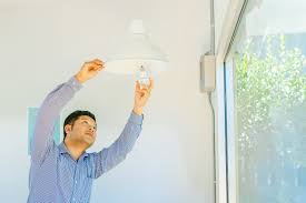 Using shunted lamp holders or tombstones when led retrofitting can damage the bulbs or the fixture itself. Asian Man Changing Light Bulb In Coffee Shop Installing A Fluorescent Light Bulb Ucla Luskin Center For Innovation