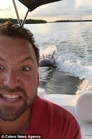 Speedboat captain films the moment a dozen dolphins start frolicking around  him