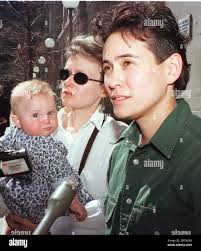 Kay Schmidt, foreground-right, and her partner Diane Pullen, seen holding  their daughter, talk with reporters, Thursday, April 8, 1999 outside the  Suffolk County Courthouse in Boston, after their case to protect their