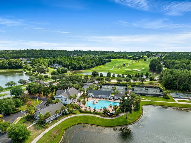Street-level view of Southern Hills Plantation with rolling hills, palm trees, and a gated community feel in Brooksville