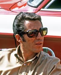 Mario Andretti at the Pikes Peak Hill Climb [1968] Mario Andretti driving  his Ford Harrison Special past parked cars at George's Corner. He took  first place in 12:54.3. Courtesy of the