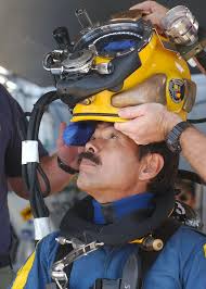 A member of the Japanese Self Defense Force Diving Team is fitted with a  MK-21 dive helmet aboard the Crowley 450-10 barge, during recovery  operations for the Japanese fishing vessel Ehime Maru -