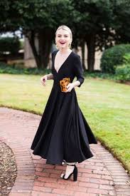 When the bride and groom will be meeting in a house of worship, you'd be better off choosing a maxi dress or a lace dress to help them celebrate. Picture Of A Black Maxi Dress With A Pleated Skirt A Plunging Neckline And Long Sleeves Block Heels And An Animal Print Clutch Which Is A Trend