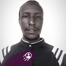 Hon.Dan Kimosho,MP Kazo County & the LCV Chairman,Rev.Samuel Katugunda  stand behind Wilson Nkaija (seated) during the NRM district elections.  Nkaija defeated Nkoreki Chrissy Abel to retain the seat at the district NRM