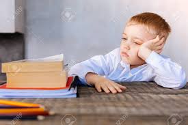 Time For Homework. Unhappy Nice Serious Boy Sitting At The Desk ...